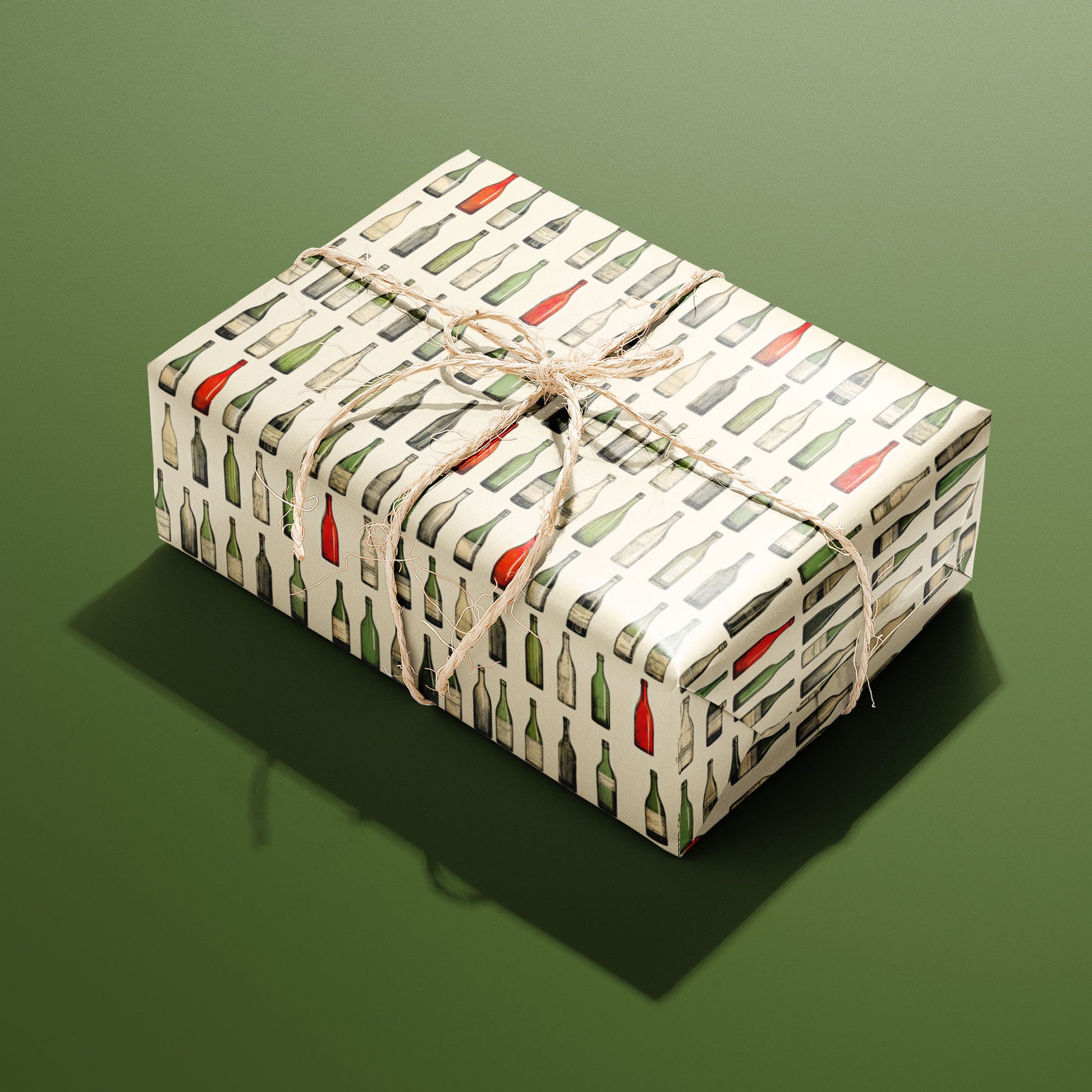A single rectangular gift wrapped in Classic Vino—rows of watercolor wine bottles on cream—tied with natural twine on an olive green background.