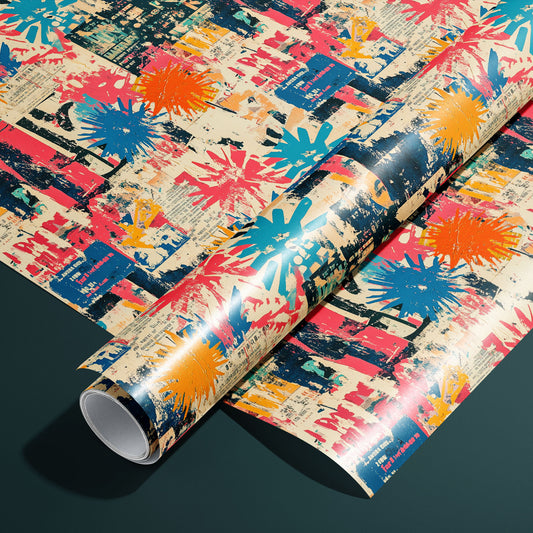 A roll of Grunge Nouveau wrapping paper on an unrolled sheet, featuring distressed Art Nouveau florals and filigree in antique gold on black, set on a dark charcoal surface.