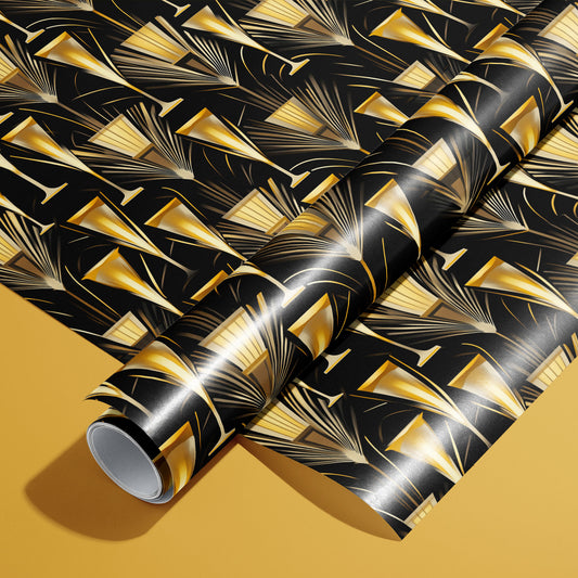 A roll of Flutes & Fans wrapping paper on an unrolled sheet, featuring art deco fans and champagne flutes in soft gold on black, set on a deep golden surface.