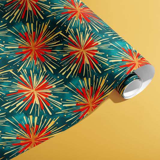 A partially unfurled roll of Celestial Celebration wrapping paper reveals red and gold firework starbursts across deep teal on a golden yellow background.