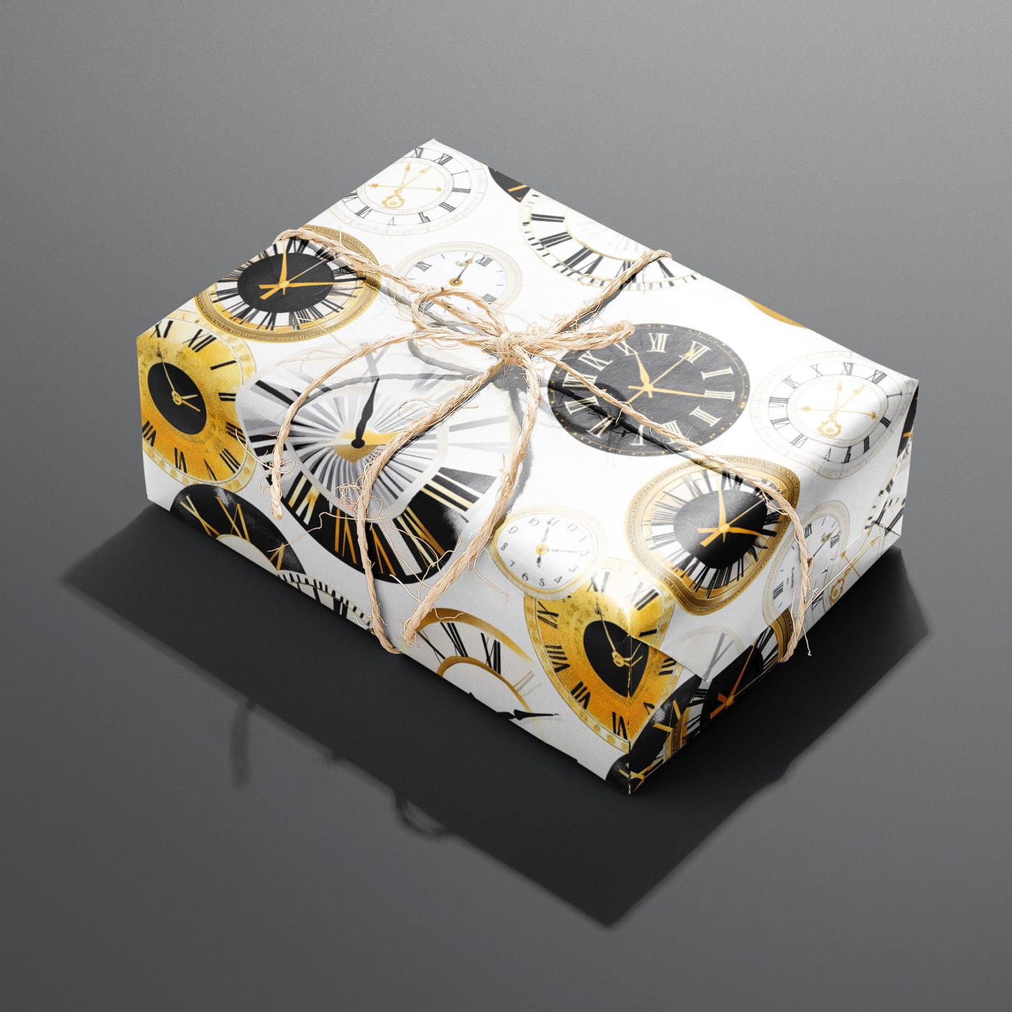A single gift wrapped in Luxe Time and tied with natural twine, displaying gold, black, and white clock faces with Roman numerals on white, set on a dark gray surface.