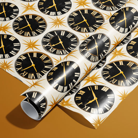 A roll of Deco Century paper on a matching unrolled sheet shows vintage black clock faces with Roman numerals and gold starbursts on pearl white, set on a golden mustard background.
