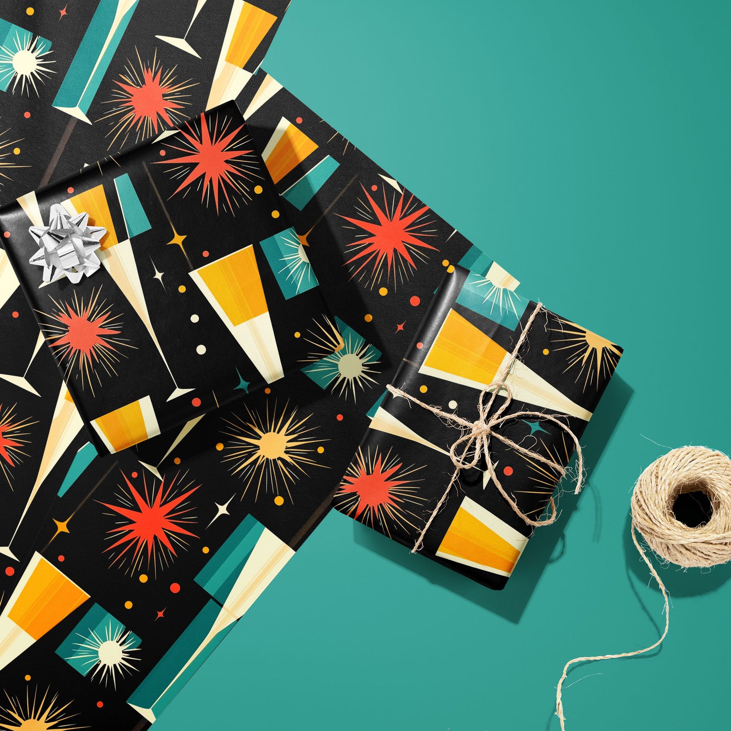 Two gifts wrapped in Midcentury Starburst—one with a silver bow and one tied with twine—rest on two unused sheets beside a twine spool on a teal surface, with starbursts and champagne flutes.