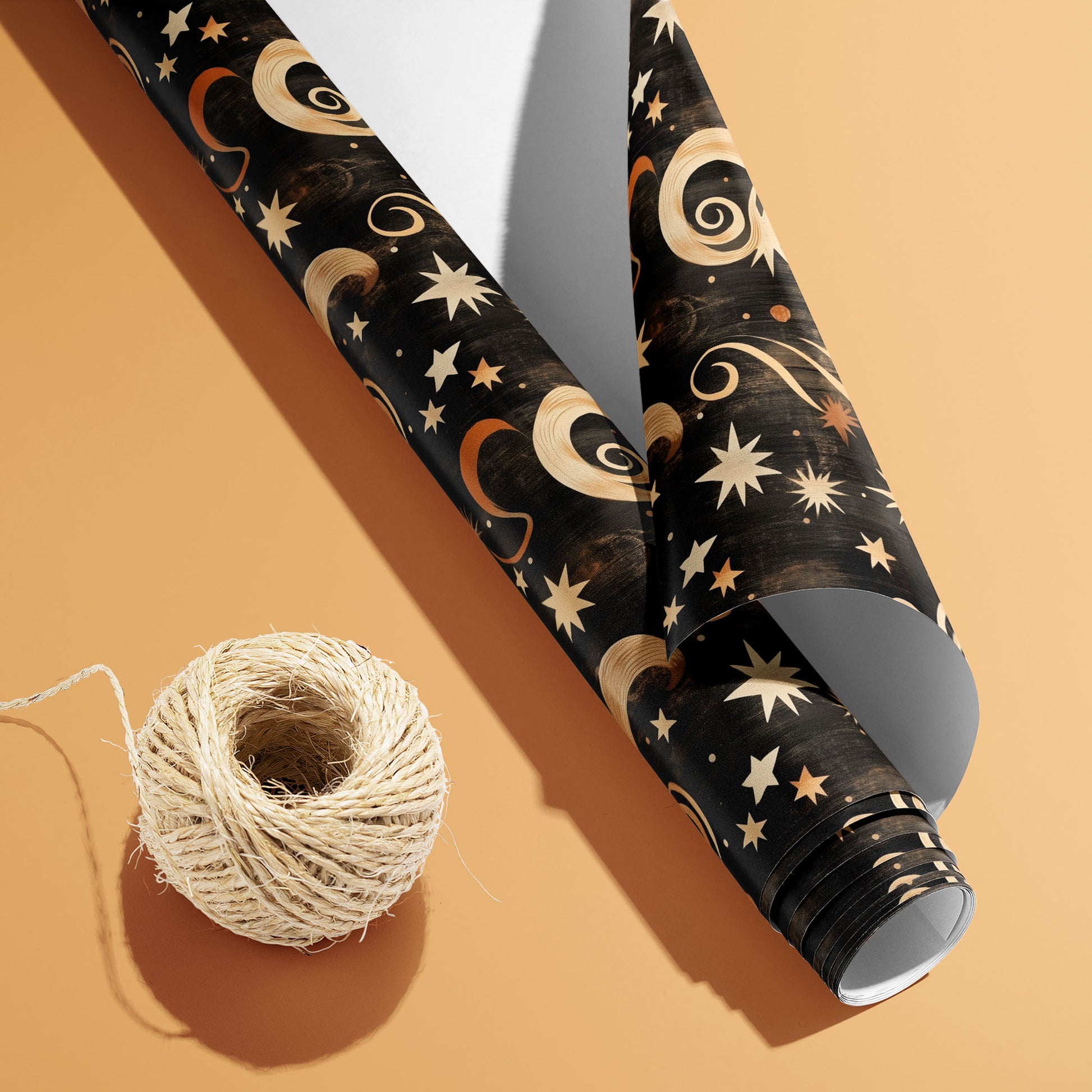 A partially unfurled roll of Golden Stardust showing the white underside beside a spool of natural twine, with gold stars and celestial swirls on a warm peach background.