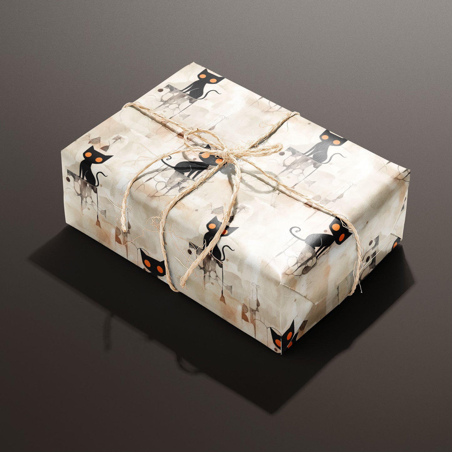 A rectangular gift wrapped in Contemporary Black Cats paper and tied with natural twine shows sleek black cats with orange eyes on a watercolor beige ground against a deep espresso background.