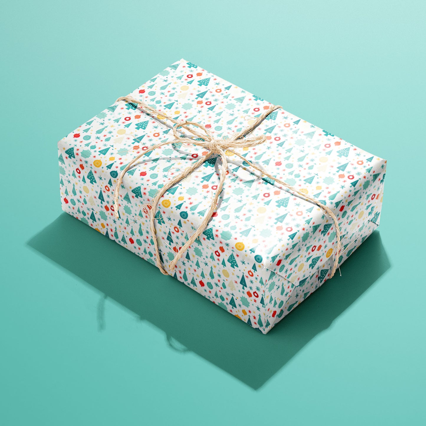 A single rectangular gift wrapped in Childlike Christmas paper, the whimsical doodle pattern tied with natural twine, set on a soft mint-green background.