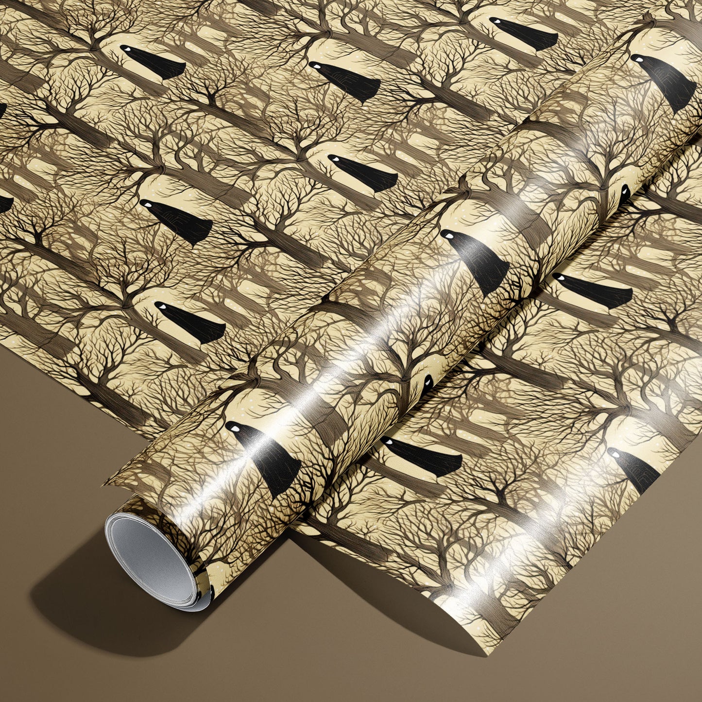 A roll of Silent Forest wrapping paper rests on an unrolled sheet, featuring leafless trees and cloaked figures on a parchment-tan ground, styled on a warm brown surface.