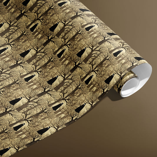 A partially unfurled roll of Silent Forest gift wrap shows repeating bare trees with hooded silhouettes on a parchment-tan ground against a warm brown background.