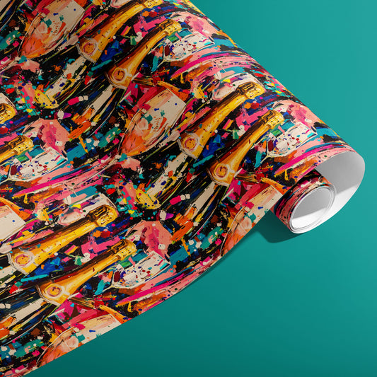 A partially unfurled roll of Cheers in Color paper showing painterly champagne bottles and confetti splashes on a dark ground against a teal surface.