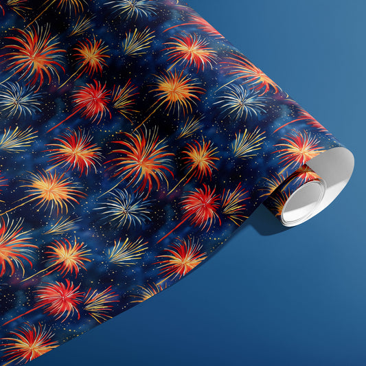 A partially unfurled roll of Blooming Sky paper showing hand-painted fireworks and tiny sparkles across a deep navy sky print, set against a steel-blue surface.