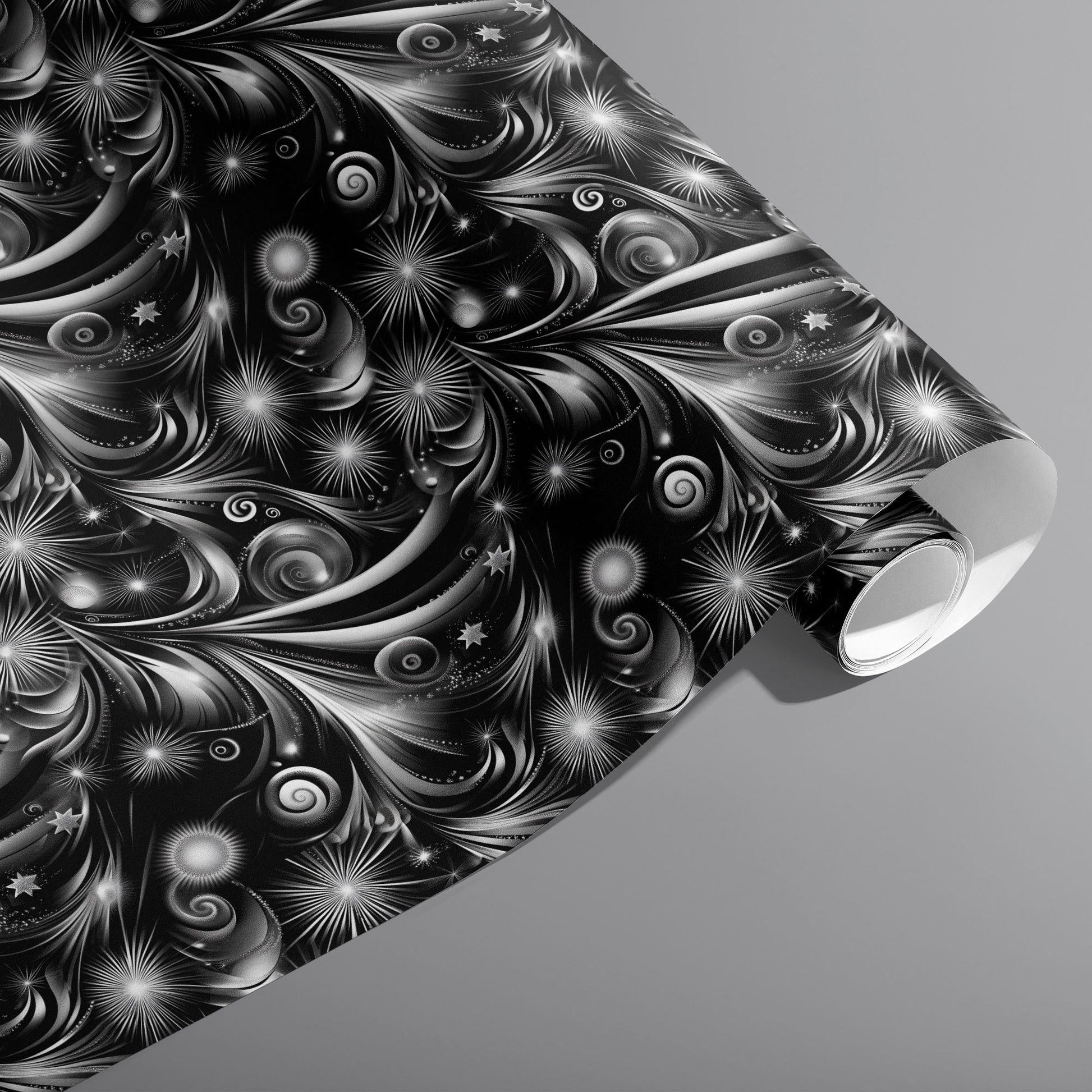 A partially unfurled roll of Fireworks Finale featuring monochrome fireworks—starbursts and swirling trails—across a black ground on a medium gray surface.