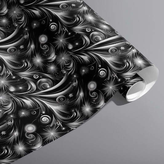 A partially unfurled roll of Fireworks Finale featuring monochrome fireworks—starbursts and swirling trails—across a black ground on a medium gray surface.