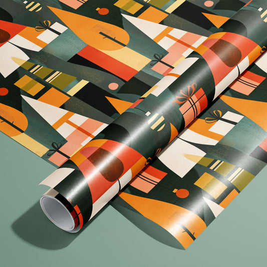 A roll of Geometric Forest wrapping paper on an unrolled sheet, showing geometric trees, gift boxes, and ornaments in orange and green on a dark print over a sage-green surface.