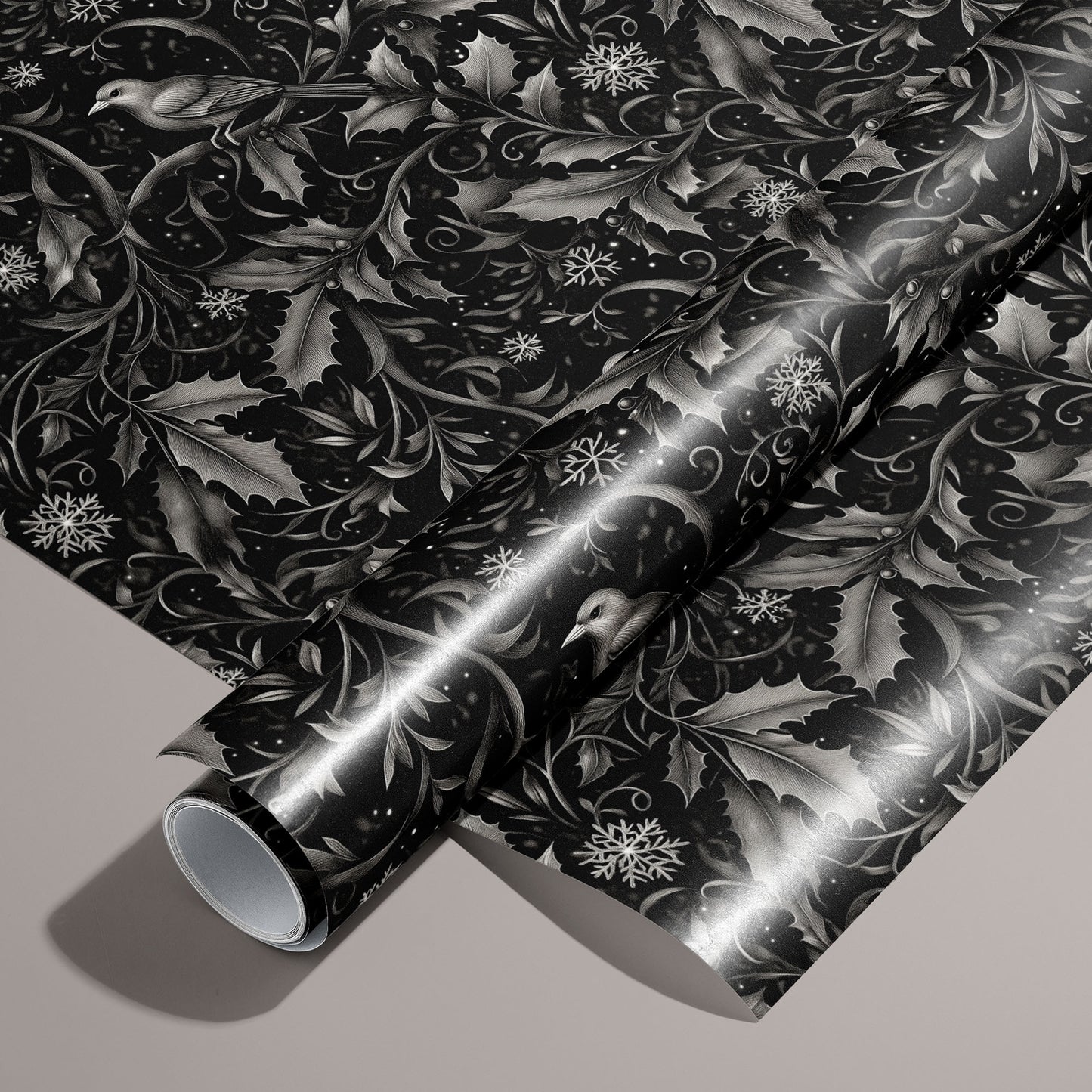 A roll of Winter Song wrapping paper rests on a matching unrolled sheet, featuring monochrome songbirds, holly leaves, and snowflakes on a black field over a warm taupe background.