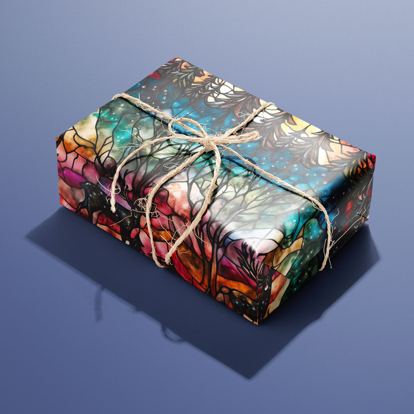 A single gift wrapped in Starlit Grace and tied with natural twine, revealing stained-glass deer, fir trees, and sparkling night stars in jewel-tone colors on a slate blue surface.