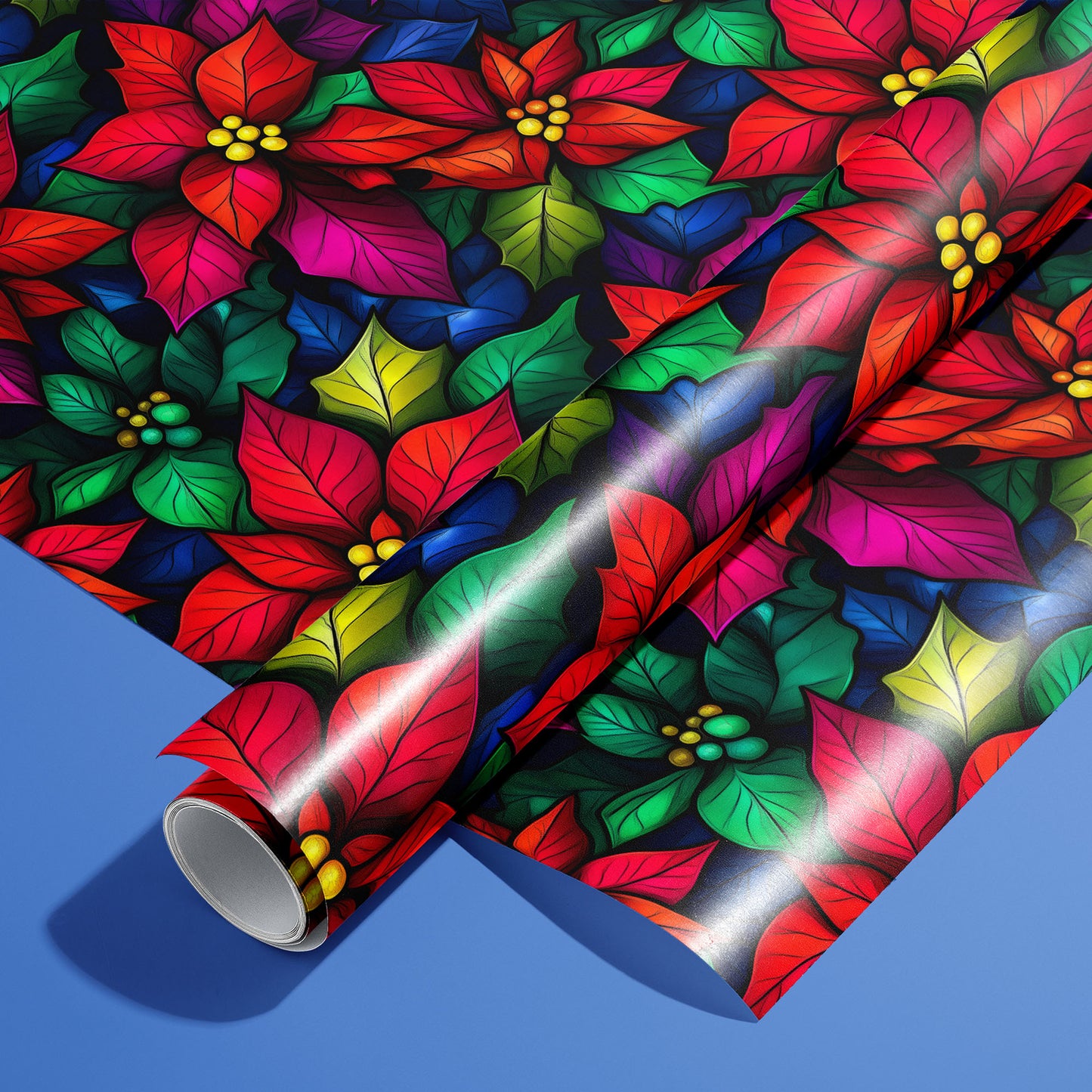 A roll of Bold Blooms wrapping paper resting on an unrolled sheet, featuring vivid poinsettias and jewel-tone leaves on a black ground, set on a bright cobalt-blue surface.