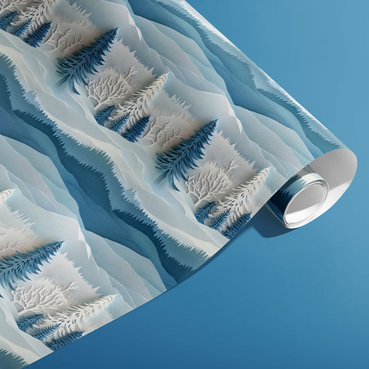 A partially unfurled roll of Snowy Grove wrapping paper showing stylized snowy evergreens and bare branches in tonal blues on a medium blue background.
