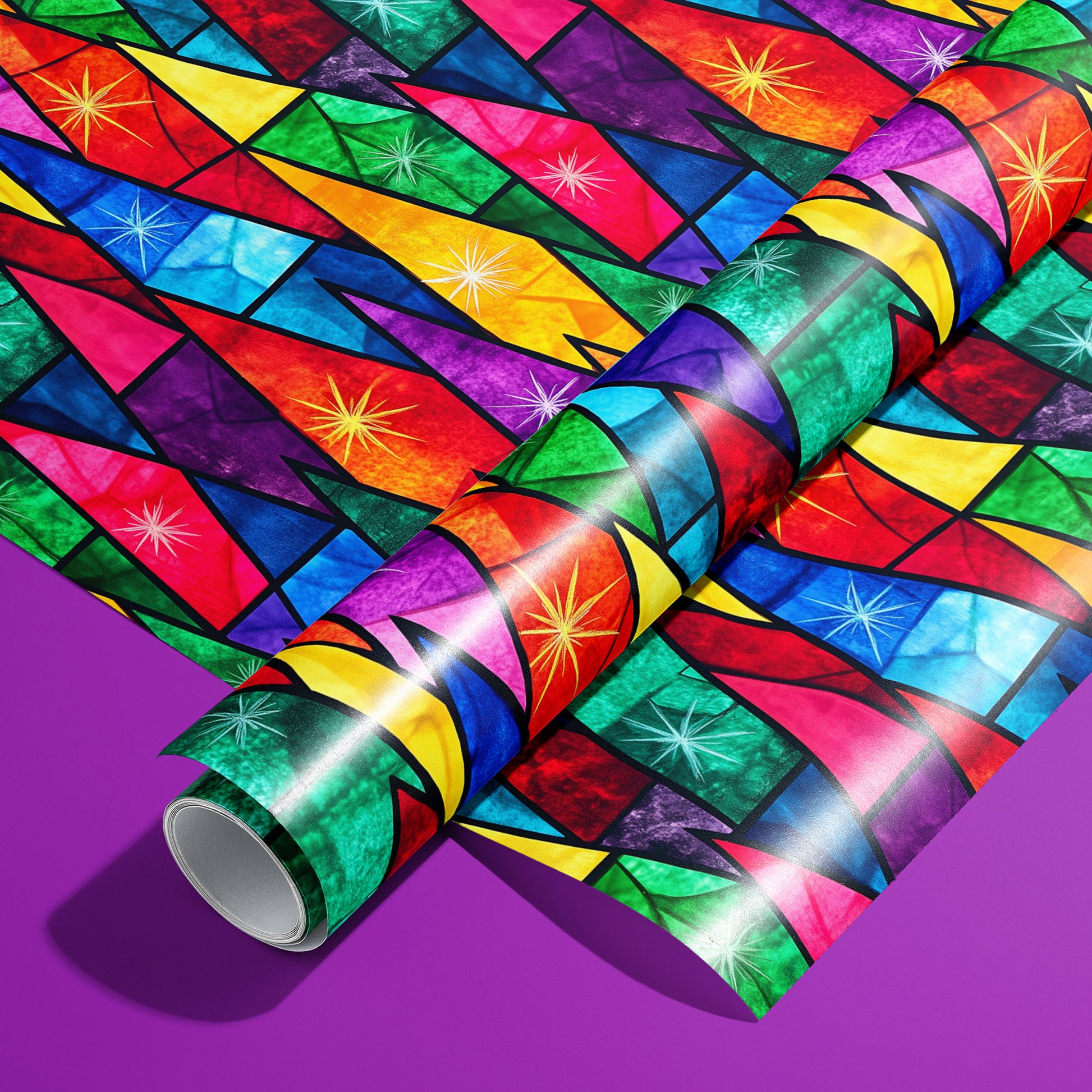 A roll of Prismatic Holiday wrapping paper on an unrolled sheet, with stained-glass prism shards and starbursts in rainbow jewel tones, set on a vibrant purple surface.