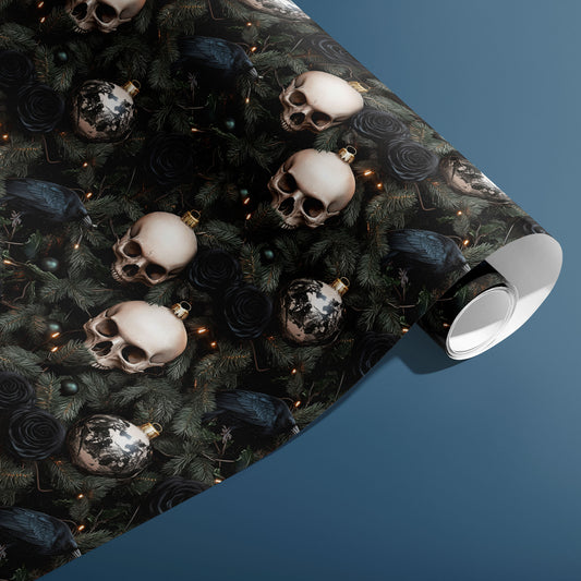A partially unfurled roll of Dark Yuletide shows skull baubles, dark roses, ravens, and pine sprigs dotted with tiny lights on a black field against a steel blue backdrop.