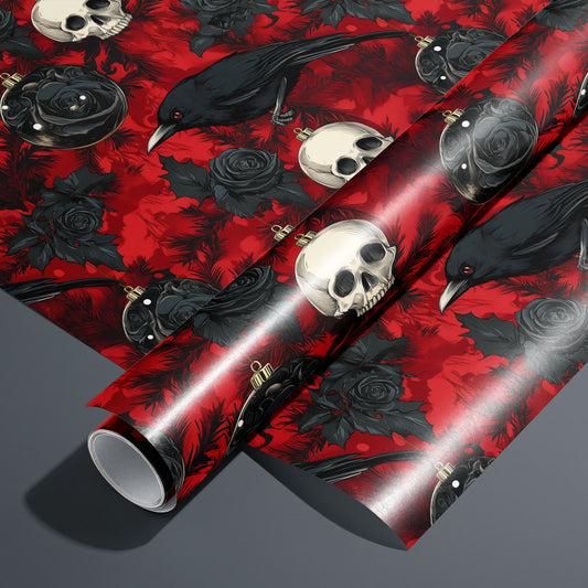 A roll of Merry Macabre rests on an unrolled sheet, showing ravens, ivory skulls, black roses, and dark glass ornaments amid inky pine boughs on a crimson ground, styled on a charcoal gray surface.
