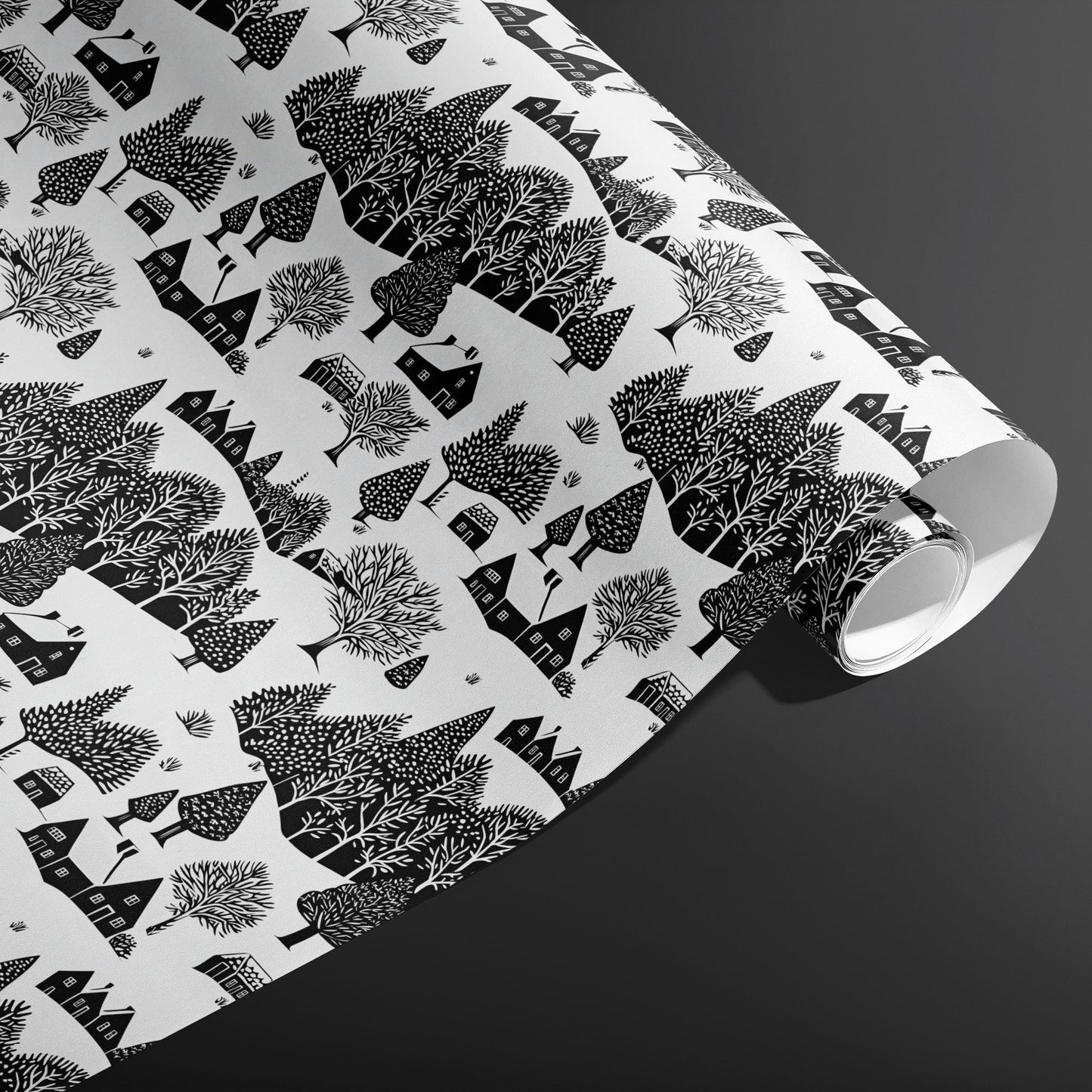 A partially unfurled roll of Snowbound Village showing cozy cottages and snow-dotted trees in black on white against a dark gray backdrop.