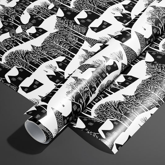 A roll of Snowy Silhouette rests on an unrolled sheet, showing black-and-white village silhouettes with snowy roofs and bare trees, styled on a charcoal gray surface.