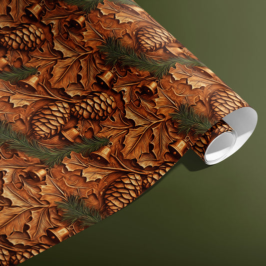 A partially unfurled roll of Pinewood Bells gift wrap displays woodcarved bells, pinecones, and oak leaves in rich brown tones against an olive green background.