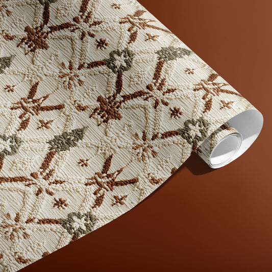 A partially unfurled roll of Festive Fibers gift wrap shows cozy knit snowflakes and tree motifs in cream, brown, and sage against a terracotta background.