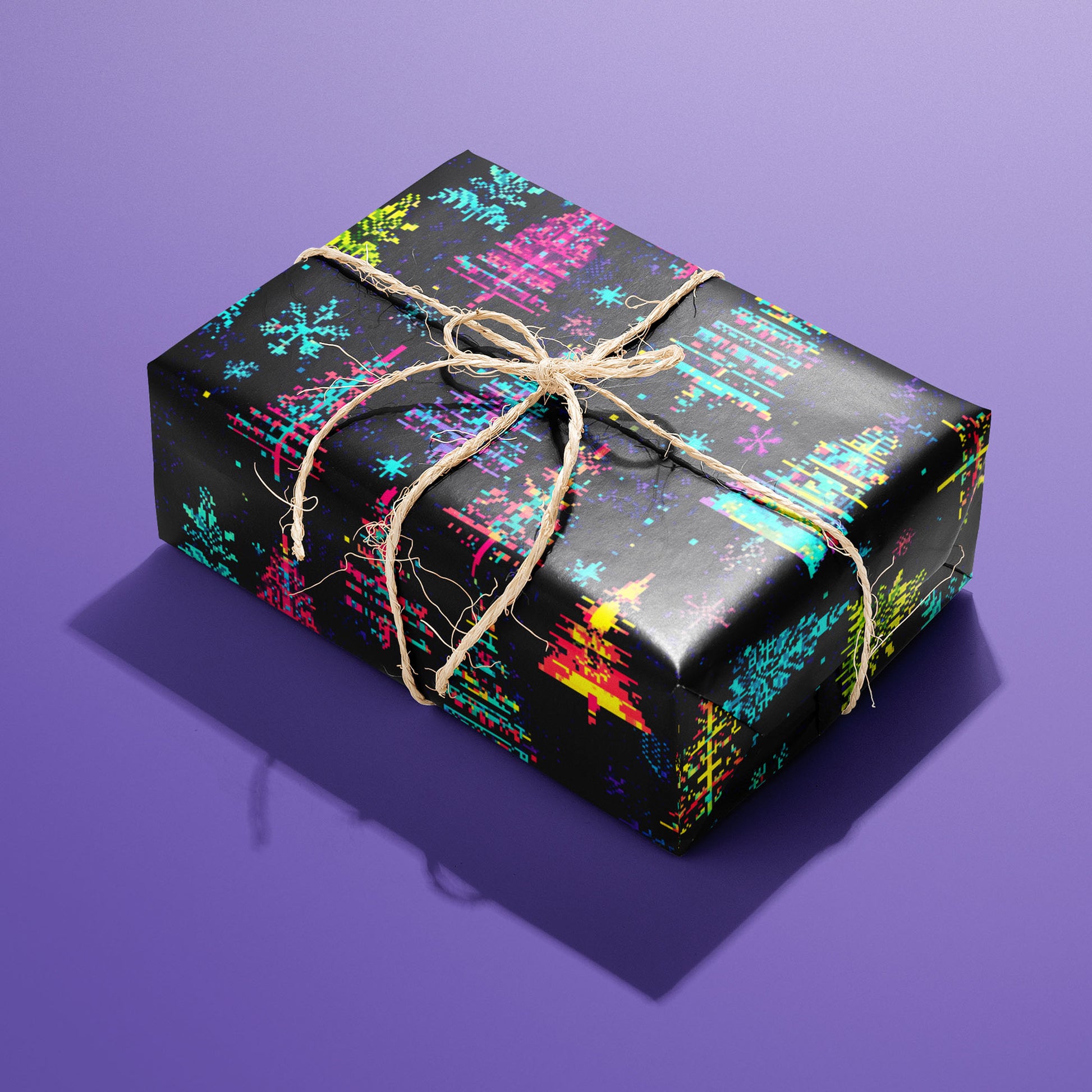 A single rectangular gift wrapped in Glitchmas Trees and tied with natural twine highlights pixel-glitched tree motifs on a dark ground against an electric purple backdrop.