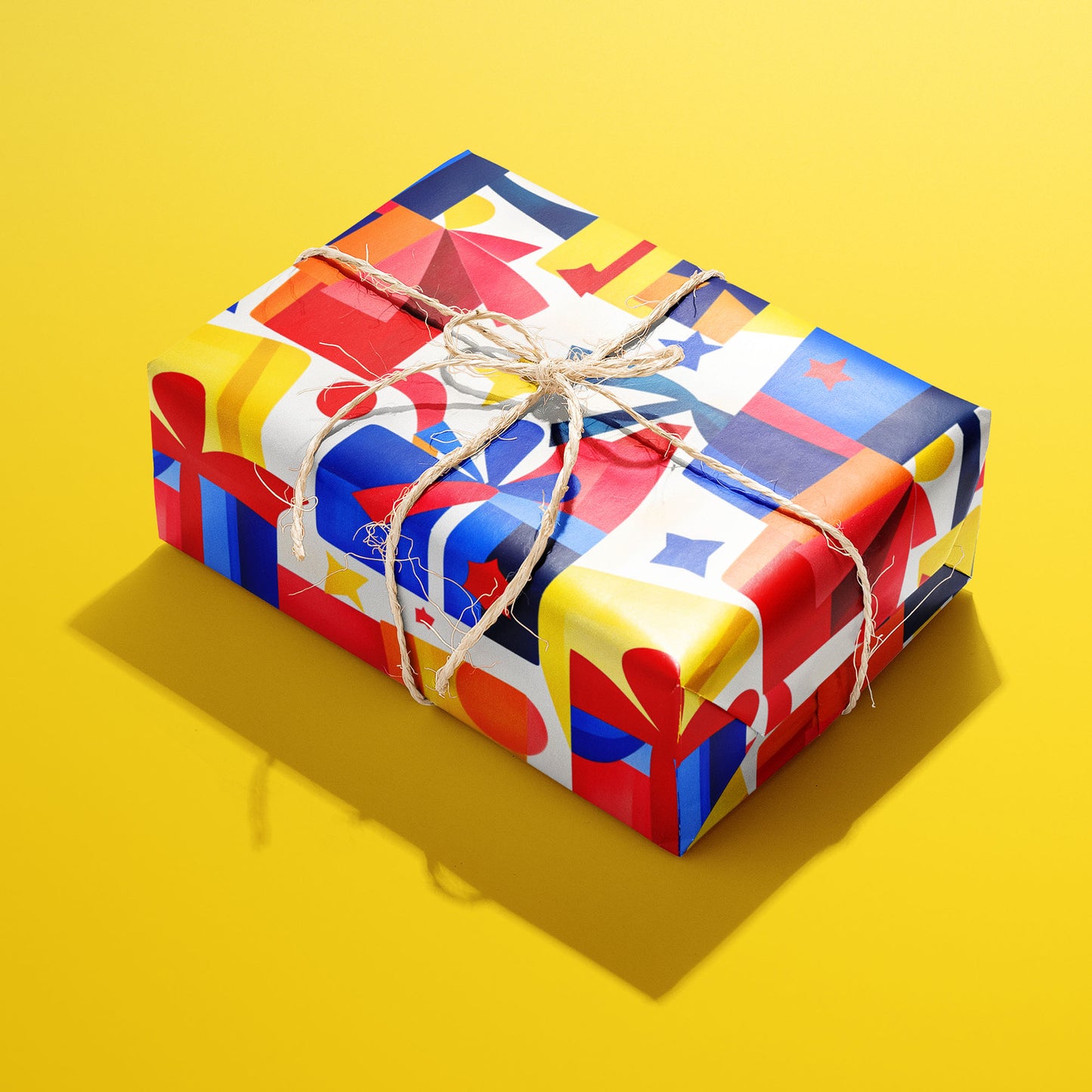 A single gift wrapped in Vivid Vintage and tied with natural twine, displaying retro gift boxes, bows, and stars in vivid red, blue, and yellow on white, on a bright yellow background.