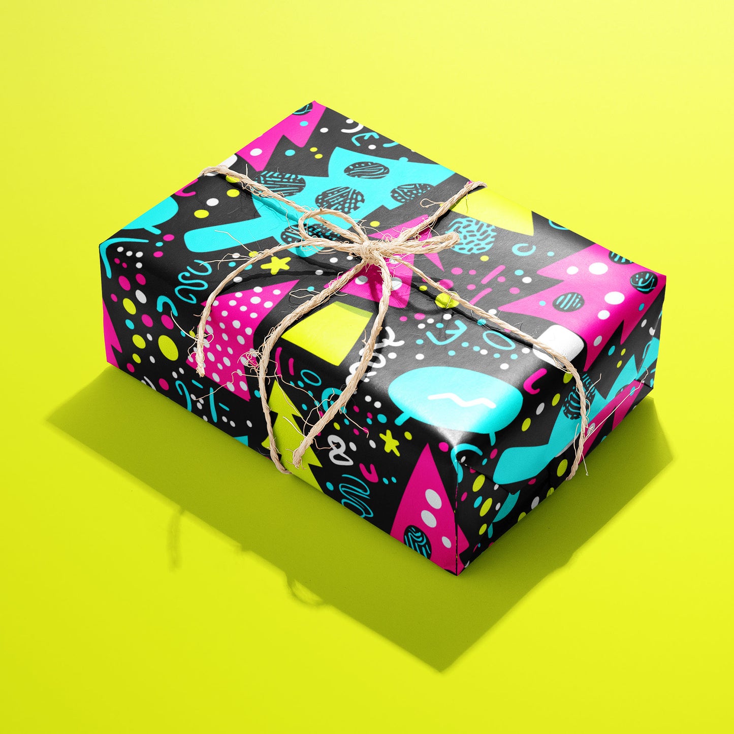 A single rectangular gift wrapped in Neon Noel paper—magenta and cyan trees with chartreuse accents—tied with natural twine on an acid-yellow background.