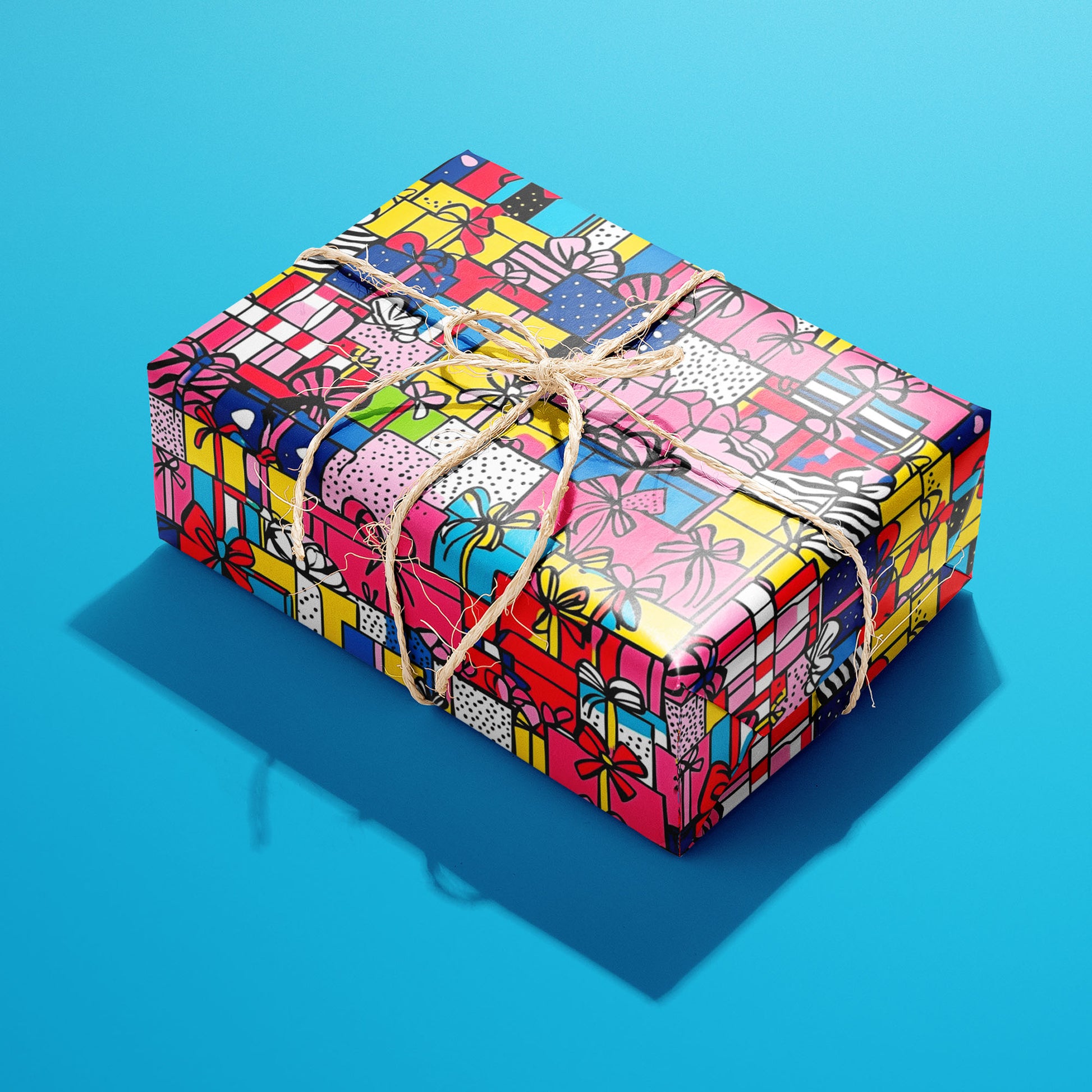 A single rectangular gift wrapped in Pop Art Presents and tied with natural twine highlights comic-style presents in vivid hues on a bright cyan backdrop.