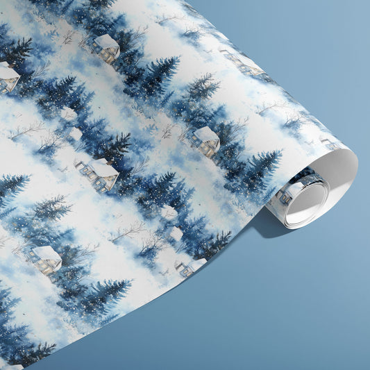 A partially unfurled roll of Winter's Calm wrap showcasing watercolor evergreens, cozy cabins, and falling snow on a dusty blue background.