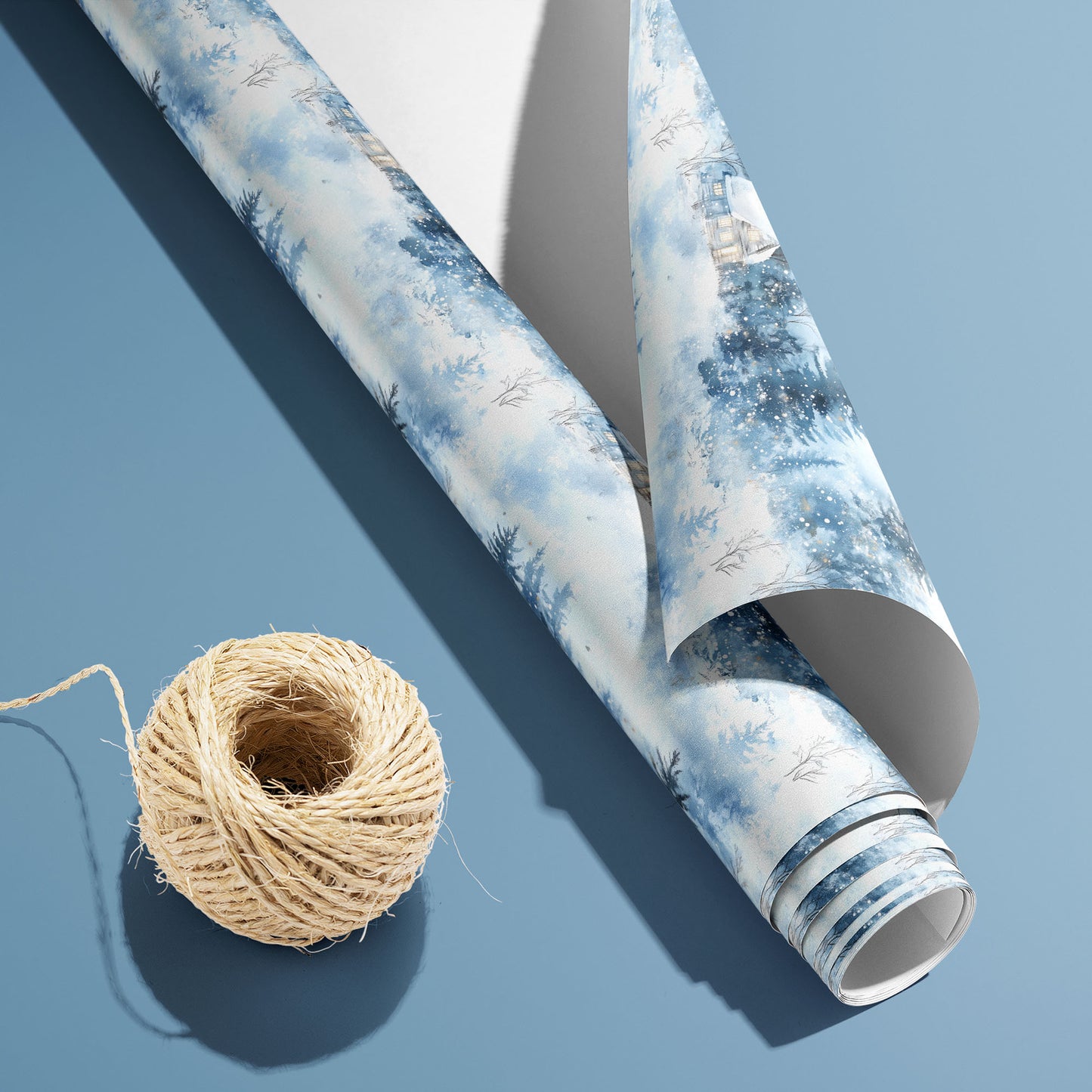 A partially unfurled Winter's Calm roll with the white underside visible beside a spool of natural twine, featuring snowy cabins and firs on a dusty blue background.