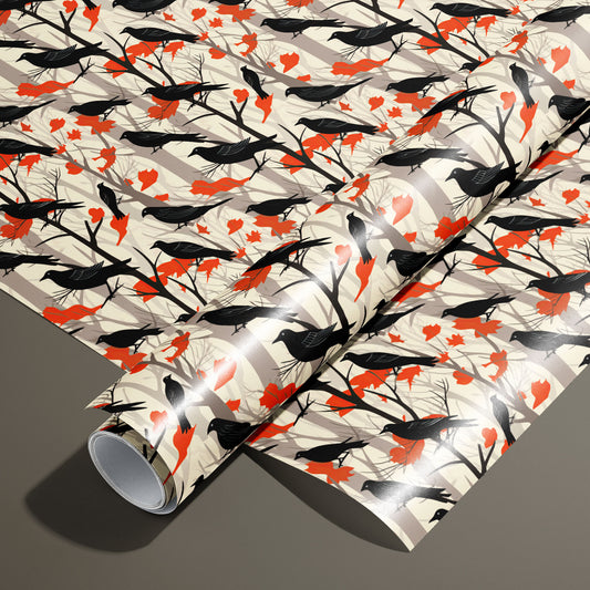 A roll on an unrolled sheet of Raven's Reverie wrapping paper with black ravens on bare branches and scarlet leaves over taupe woodland stripes, set on a smoky taupe background.