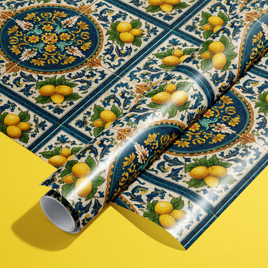 A roll of Citron Azulejo wrapping paper resting on a full sheet, featuring Mediterranean azulejo tiles with lemons and ornate florals on a bright yellow background.