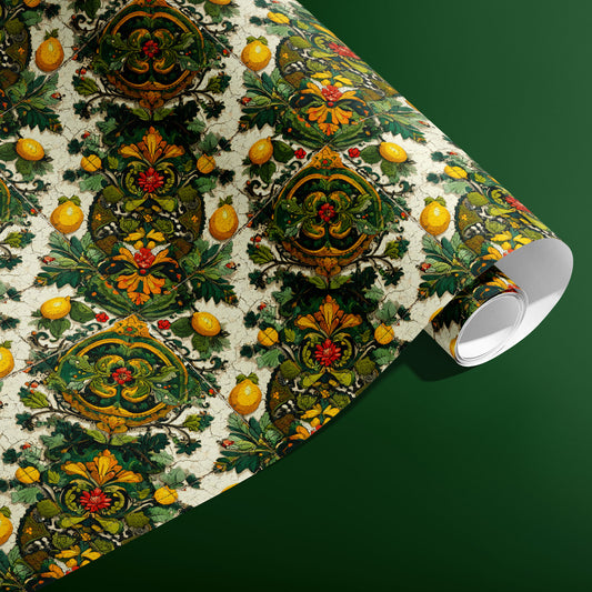 A partially unfurled roll of Amalfi Acanthus wrapping paper showcasing majolica-style lemons and ornate green acanthus motifs against a rich green surface.