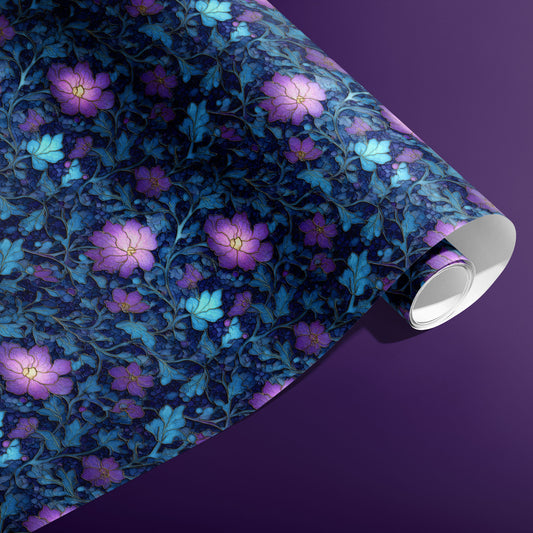 A partially unfurled roll of Lunar Hellebore wrapping paper with violet hellebore florals and teal botanicals on midnight blue, on a deep purple surface.