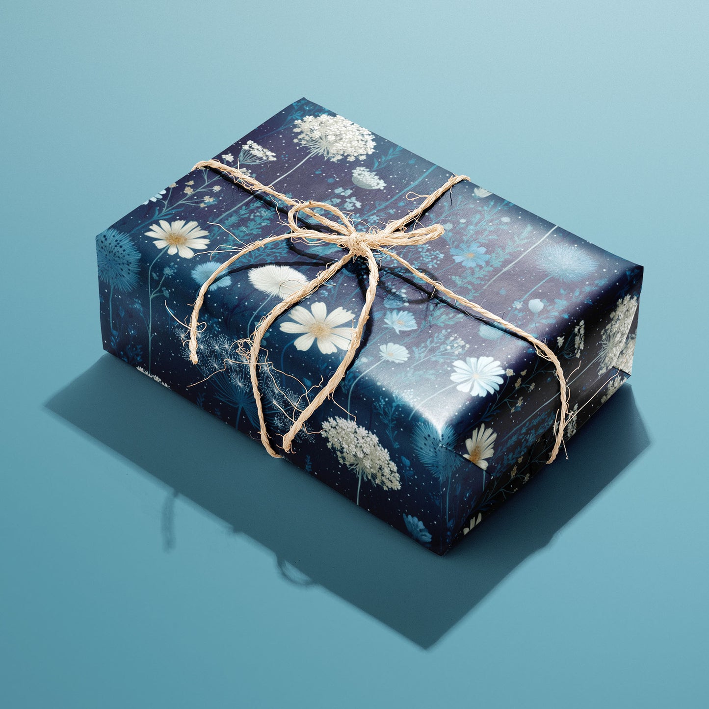 A single rectangular gift wrapped in Midnight Garden paper—blue florals and butterflies on deep navy—tied with natural twine on a teal background.