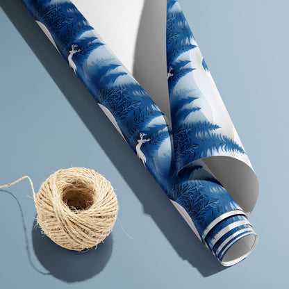 A partially unfurled roll of Alpine Serenity with its white underside visible beside a spool of natural twine, displaying snowy peaks and fir trees on deep blue over a slate-blue surface.