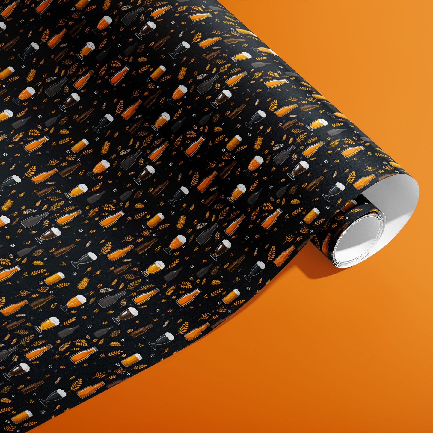 A partially unfurled roll of Midnight Hops wrapping paper showing frothy beer glasses, bottles, and barley sprigs on black against an orange background.