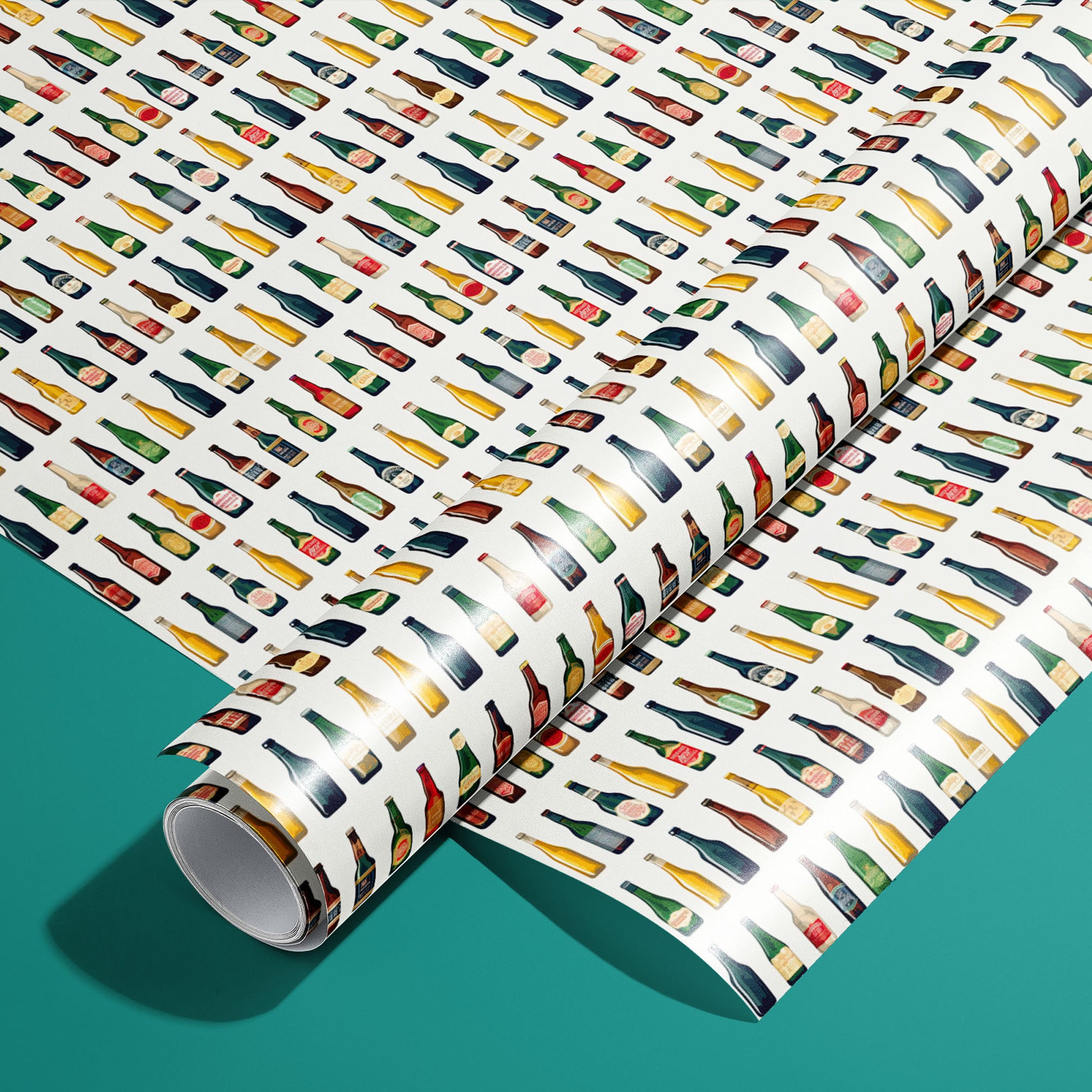 A roll of Artistic Ales rests on an unrolled sheet, featuring painterly beer bottles and foaming pints with hops and barley motifs, styled on a teal surface.