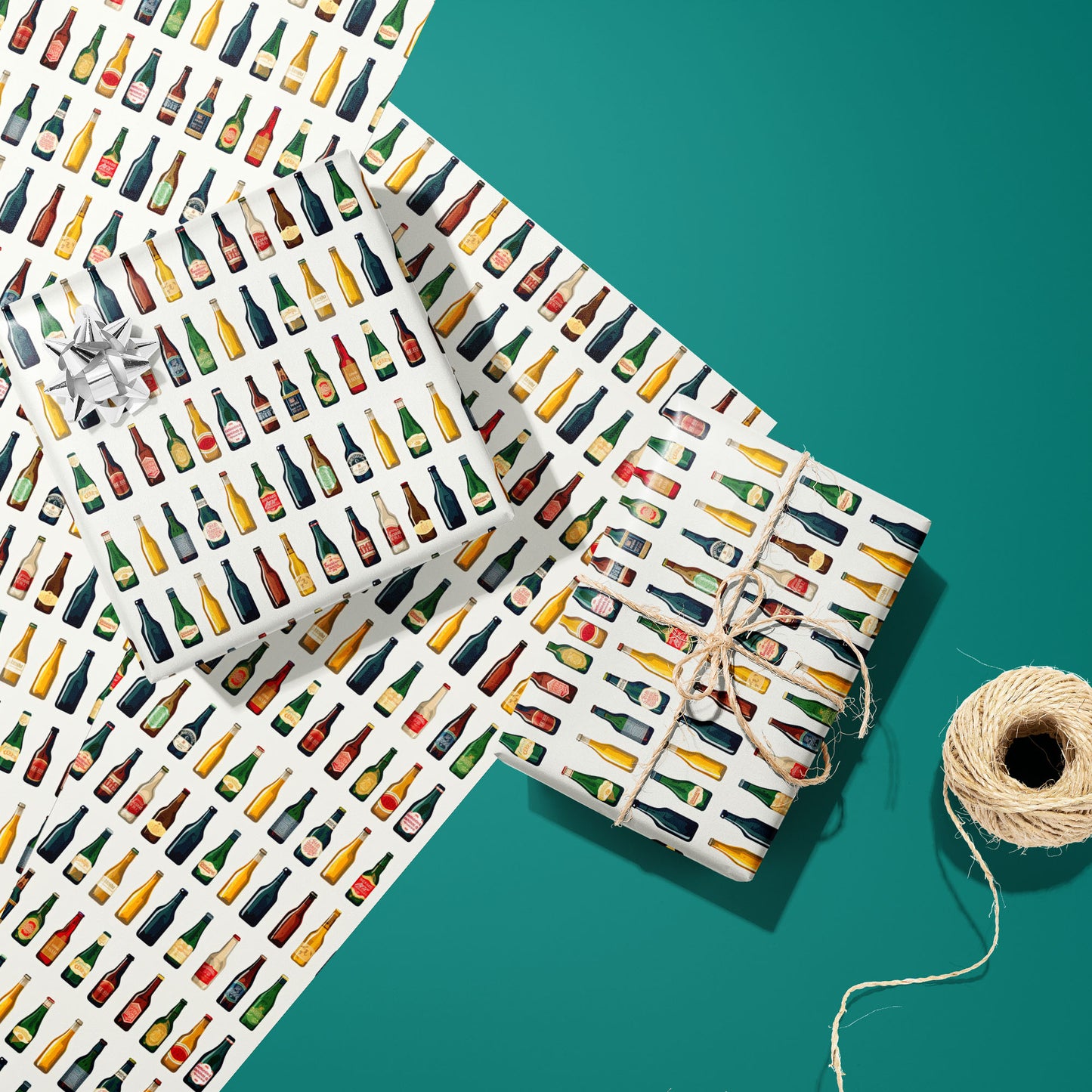 Two Artistic Ales gifts—one with a silver bow and one tied with twine—rest on two unused sheets beside a twine spool on a warm gray surface, showing beers with hops and barley.