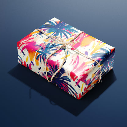 A rectangular gift wrapped in Artful Fireworks paper and tied with natural twine displays bold brushstroke fireworks in magenta, cobalt, and gold on cream resting a navy blue background.