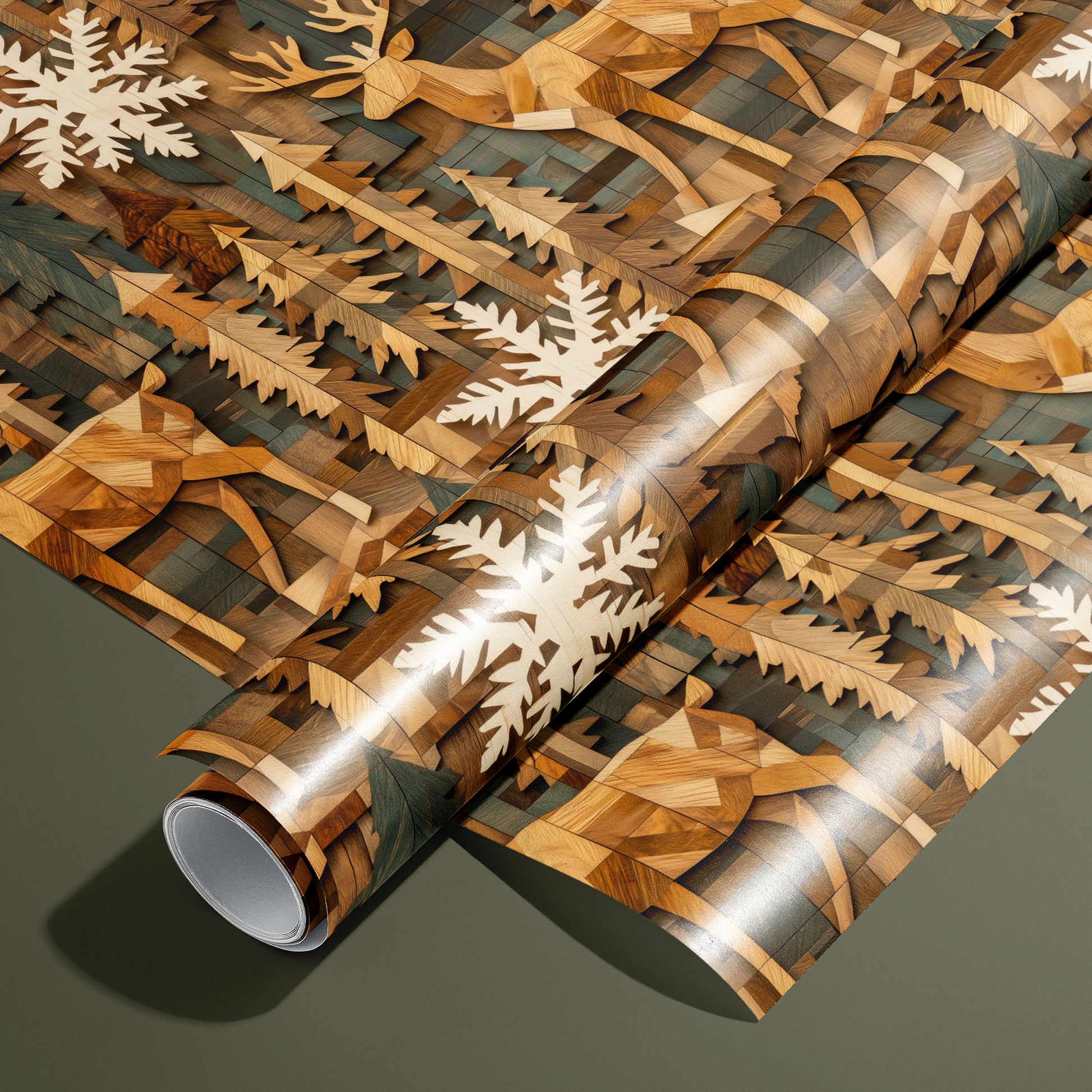 A roll of Timber Tapestry rests on an unrolled sheet, featuring wood-inlay style reindeer, evergreens, and cream snowflakes on rich wood tones, set on an olive green surface.