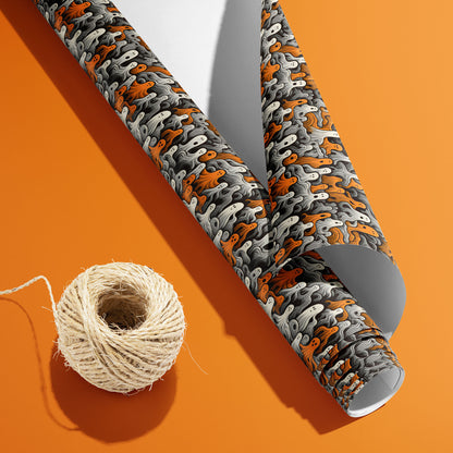 A partially unfurled Cute Ghosts roll with the white underside beside a spool of natural twine displays wavy orange, white, and gray ghosts on charcoal black over an orange background.