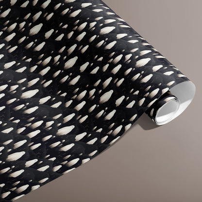 A partially unfurled roll of Halloween Ghosts wrap showing rows of ivory spirits over inky clouds on black against a warm taupe background.