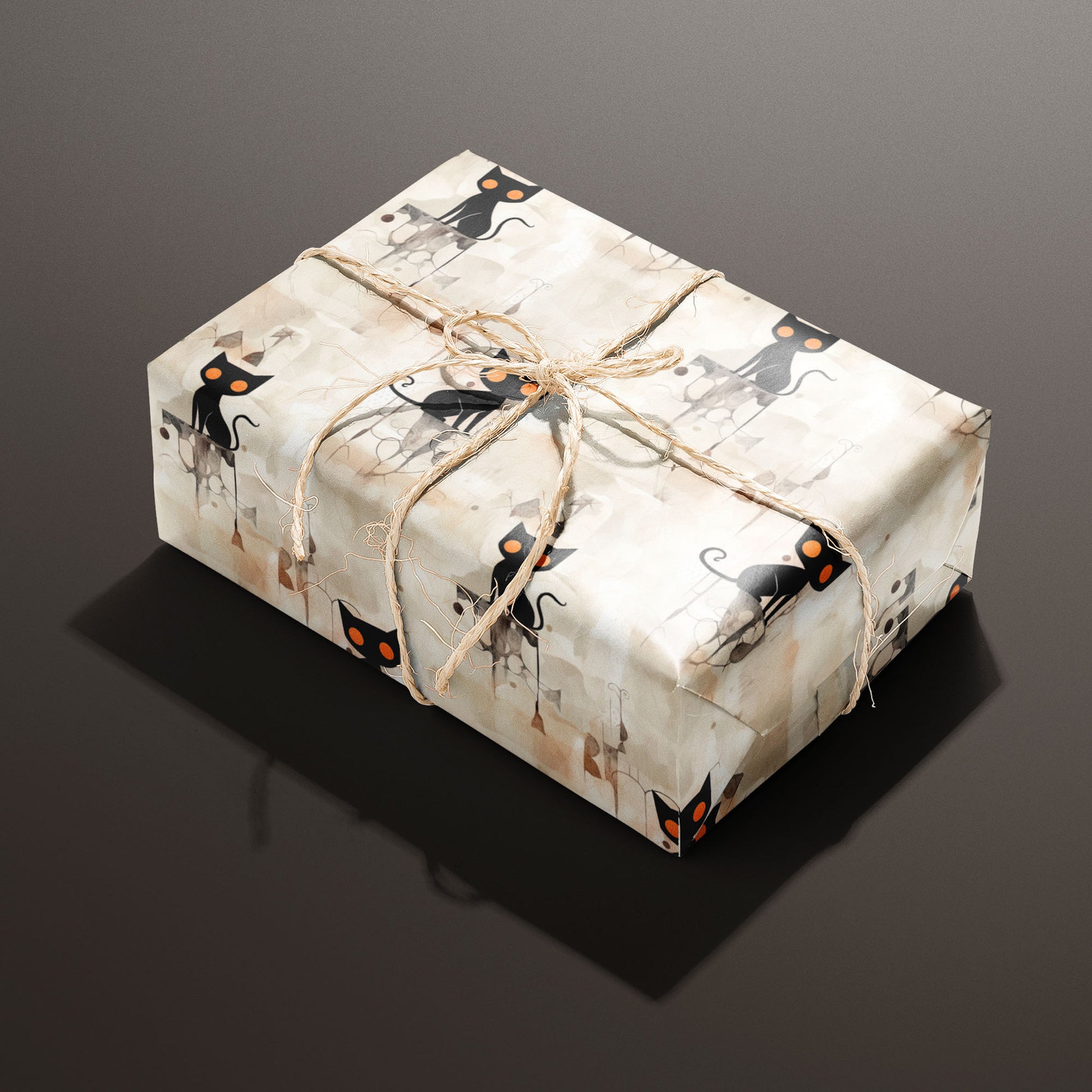 A rectangular gift wrapped in Contemporary Black Cats paper and tied with natural twine shows sleek black cats with orange eyes on a watercolor beige ground against a deep espresso background.