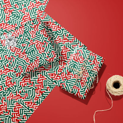 Two gifts in Geometric Xmas wrap—one with a silver bow and one tied with twine—rest on two unused sheets beside a spool of twine on a red background.