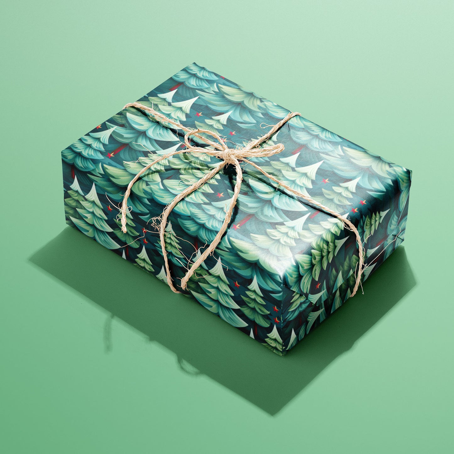 A single rectangular gift wrapped in Modern Trees paper, its layered fir motifs and red accents tied with natural twine on a mint green background.